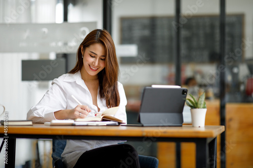 Portrait of Beautiful young smiling Asian entrepreneur businesswoman working whit laptop computer in modern office.