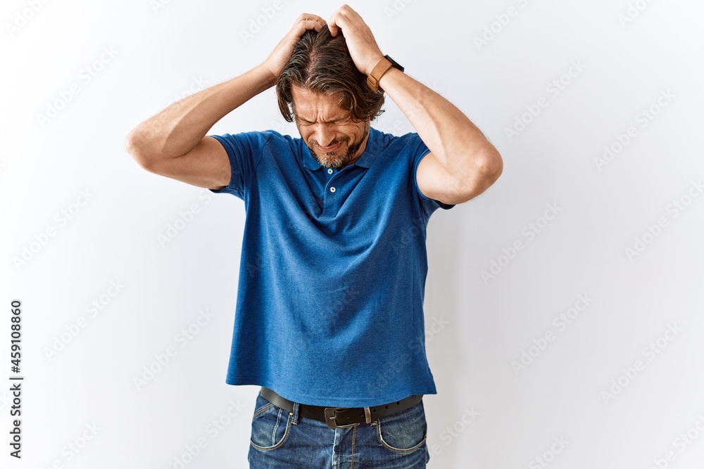 Handsome middle age man standing together over isolated background suffering from headache desperate and stressed because pain and migraine. hands on head. Handsome middle age man standing together over isolated background suffering from headache desperate and stressed because pain and migraine. hands on head.