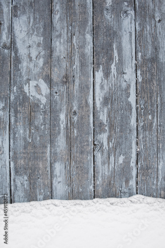 blue wood texture background with untouched snow, peeling paint on wood in winter