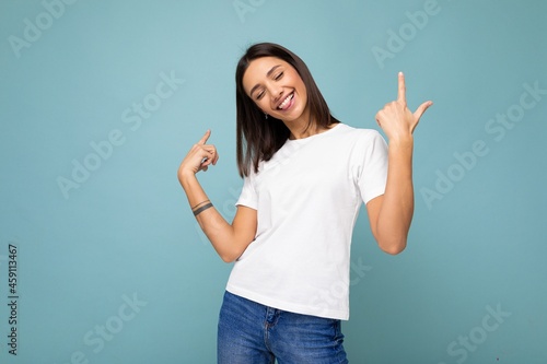 Photo of young positive happy smiling beautiful woman with sincere emotions wearing stylish clothes isolated over background with copy space