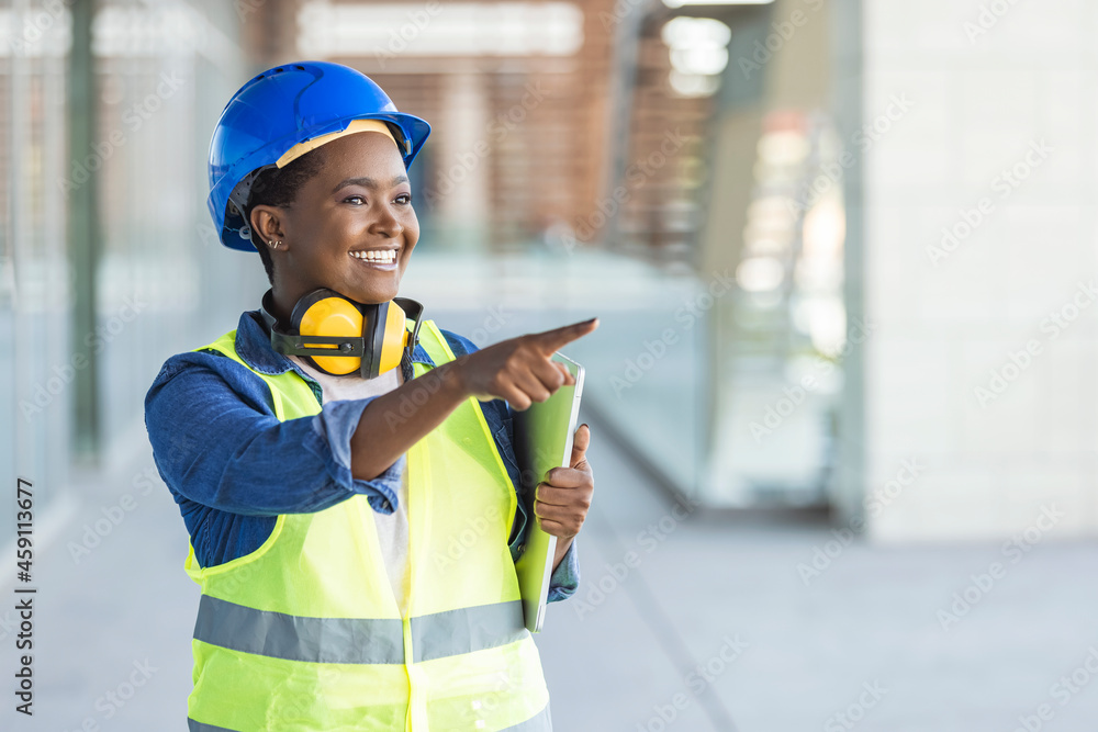 Female construction engineer. Architect with a blueprints at a construction site. Young Woman look in camera, building site place background. Portrait of adult female builder, engineer, architect, ins
