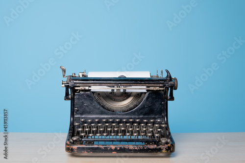 Retro vintage typewriter, front view, blue background. photo