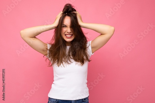Portrait of positive cheerful fashionable woman in casual white t-shirt for mock up isolated on pink background with copy space