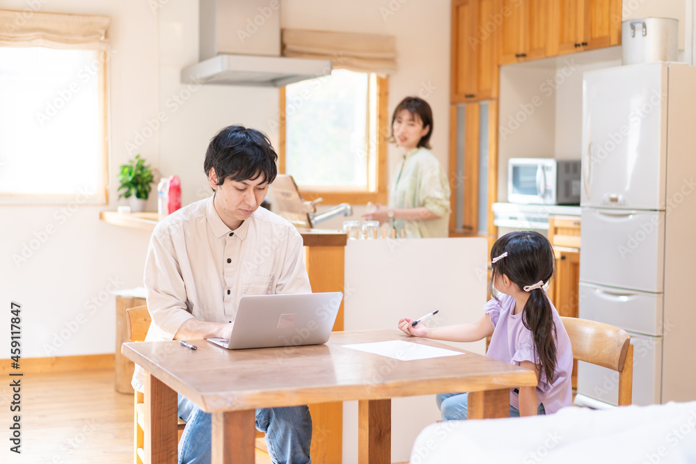 テレワークをする夫婦と子供