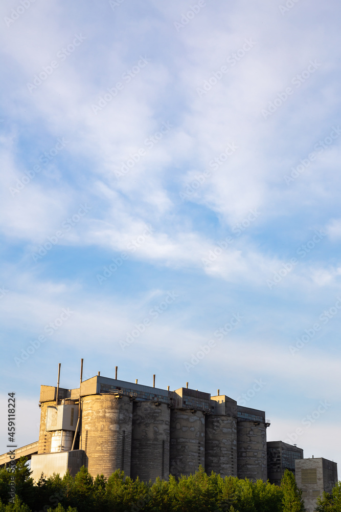 Concrete silos for loose materials against the cloudy sky. Photo taken in good lighting conditions