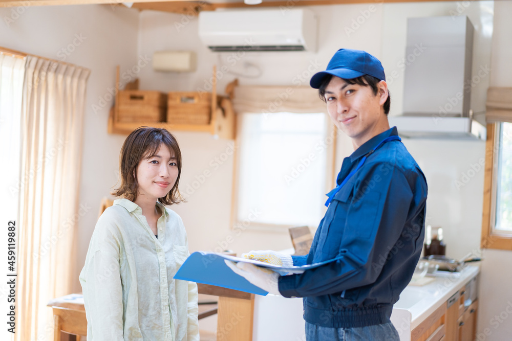 Fototapeta premium 業者に家のメンテナンスをしてもらう女性