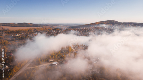 Natural background, aerial view. Autumn nature in the forest and the road passing through it.
