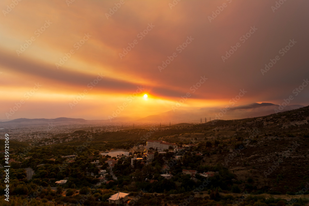 Fototapeta premium Athens view at sunset with red and yellow clouds from Penteli mountain.