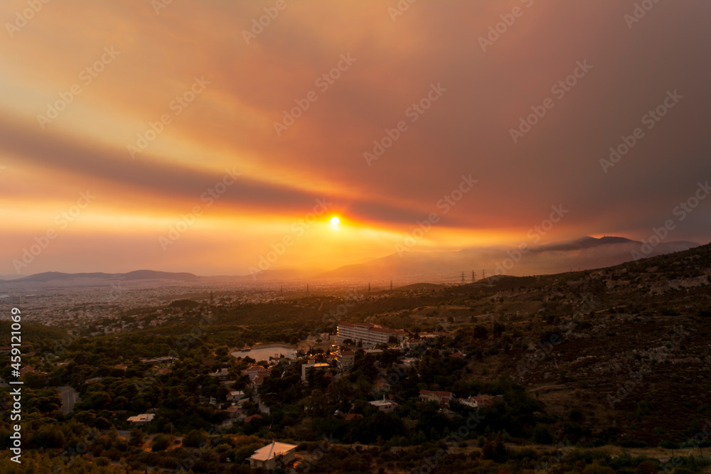 Athens view at sunset with red and yellow clouds from Penteli mountain.