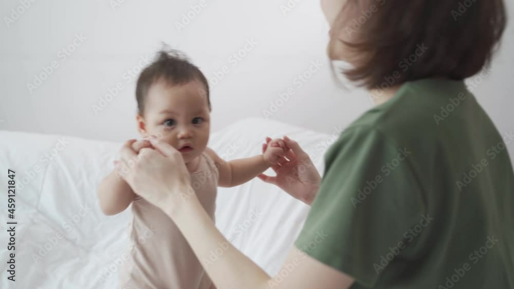asian woman mother playing with baby infant toddler on bed in bedroom at home. innocence baby good relationship parent family. child smile happy when learning lesson from mom. asian woman mother playing with baby infant toddler on bed in bedroom at home. innocence baby good relationship parent family. child smile happy when learning lesson from mom.