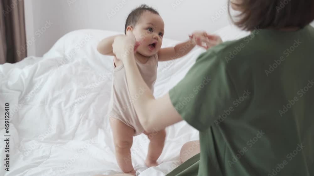 asian woman mother playing with baby infant toddler on bed in bedroom at home. innocence baby good relationship parent family. child smile happy when learning lesson from mom. asian woman mother playing with baby infant toddler on bed in bedroom at home. innocence baby good relationship parent family. child smile happy when learning lesson from mom.