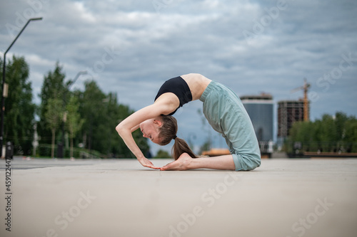 Girl practice yoga and meditation in the city.