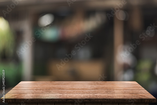 Empty wooden table top with lights bokeh on blur restaurant background. © DEEP PIXEL