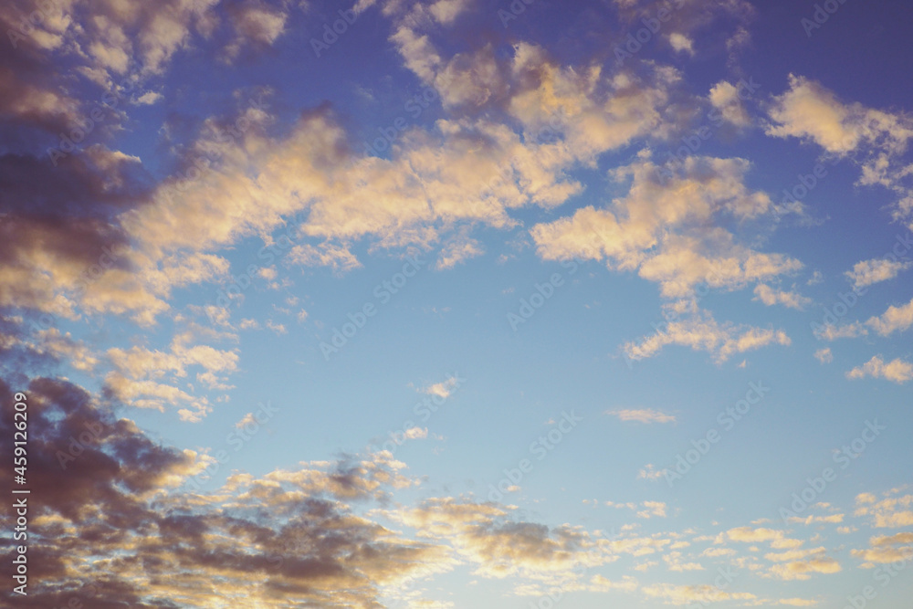 Blue sky, light and dark clouds at sunset. Cloudscape background or backdrop. Natural wallpaper. End of a sunny day
