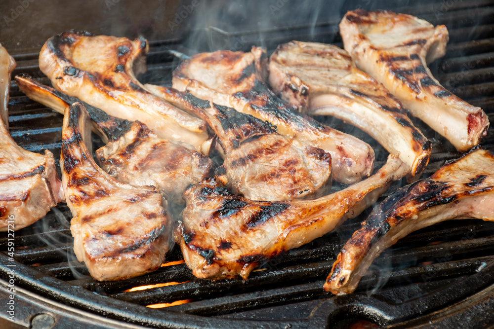 Lamb cutlets chops grilling on barbecue plate . Backyard BBQ grill cooking. Australia Day celebration
