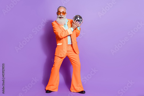 Full size photo of old funky happy man wear sunglass hold hand disco ball club isolated on purple color background
