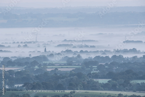 Beautiful late Summer morning over misty layers on South Downs National Park landscape