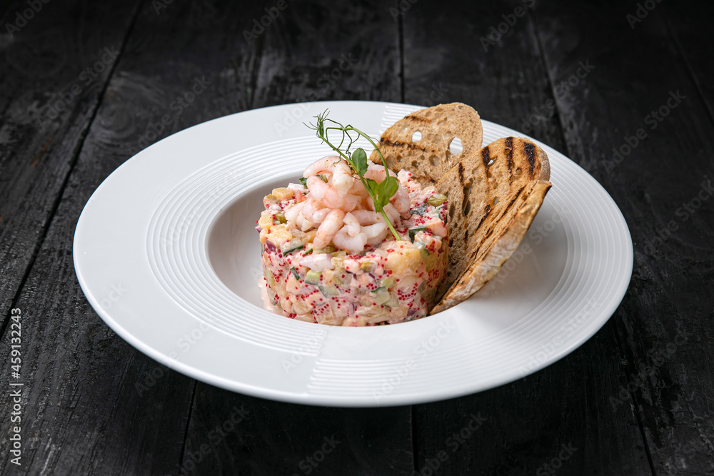 Olivier salad with seafood and caviar on a dark table
Olivier salad with seafood and caviar on a dark table