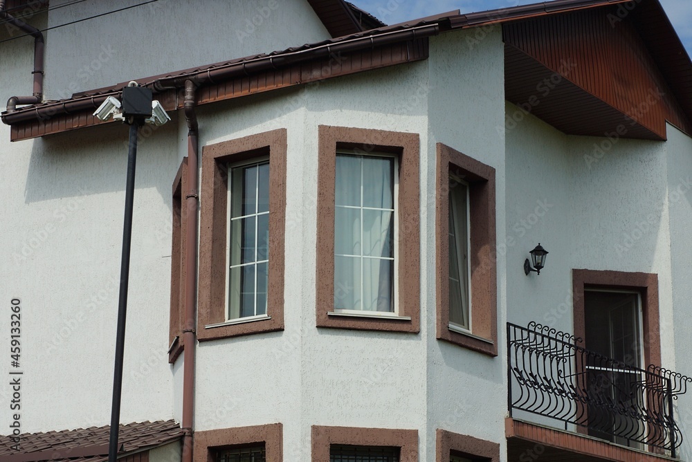 white brown concrete balcony with windows in the attic of a private house