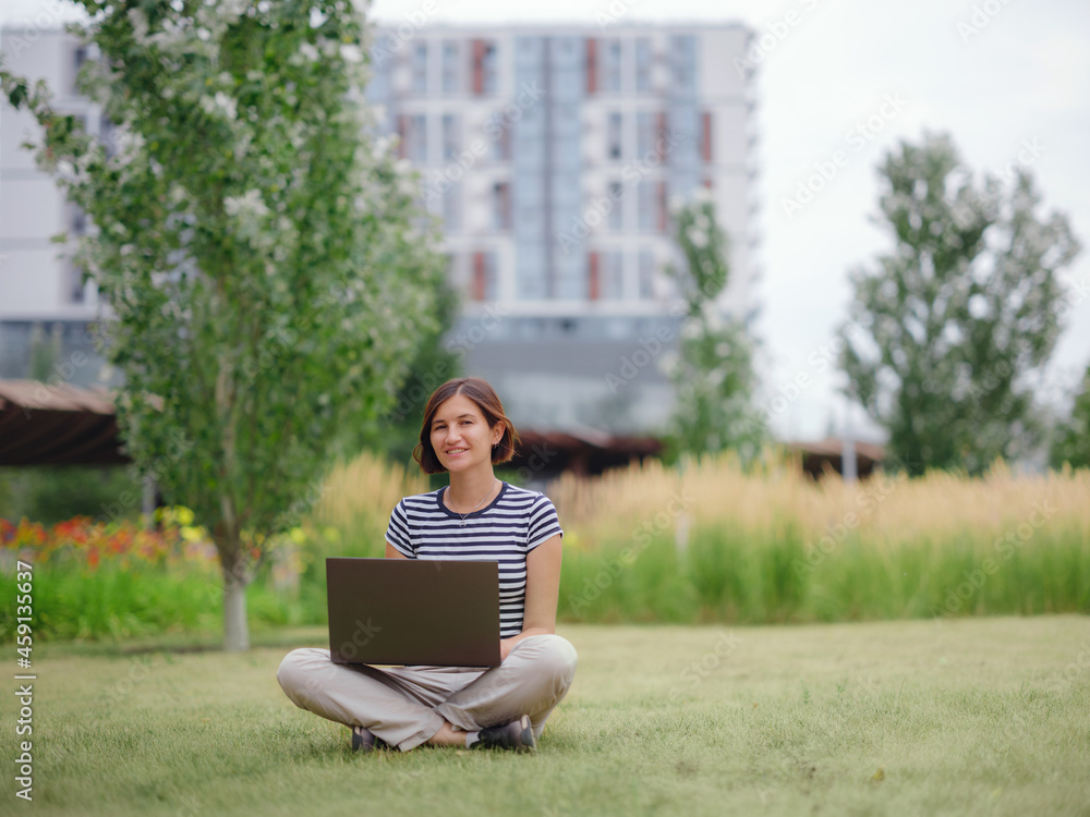 woman working with laptop in modern university campus park.