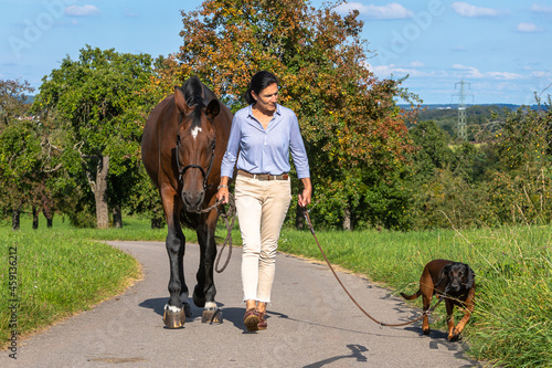 woman with dog and horse walking
