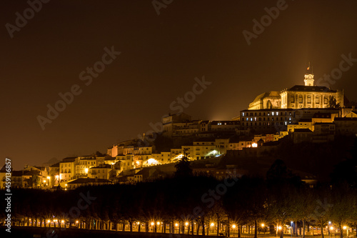 Université de Coimbra illuminée de nuit avec la mondego en avant plan