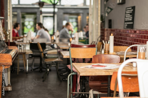urbanes Restaurant in Großstadt mit vintage Möbeln und Gästen im Hintergrund © creativemariolorek