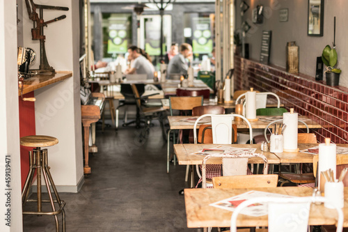 urbanes Restaurant in Gro  stadt mit vintage M  beln und G  sten im Hintergrund