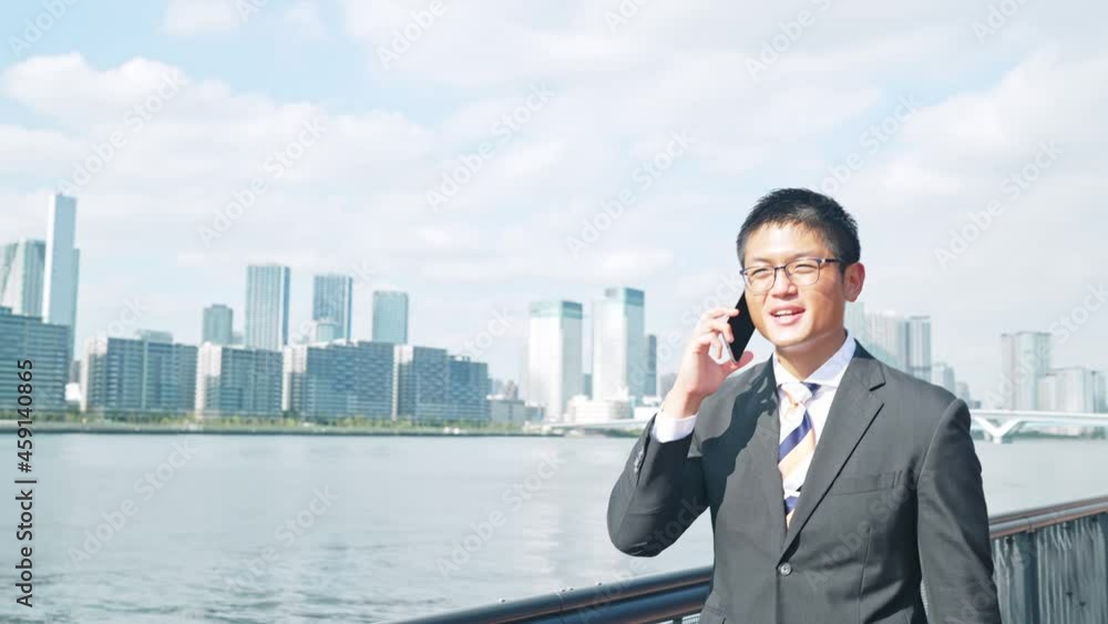 歩きながらスマホで通話する男性 歩きながらスマホで通話する男性