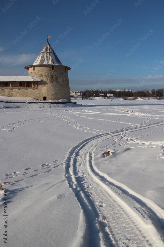 View of the Flat tower of Pskov krom from the side of the frozen Pskova river in winter