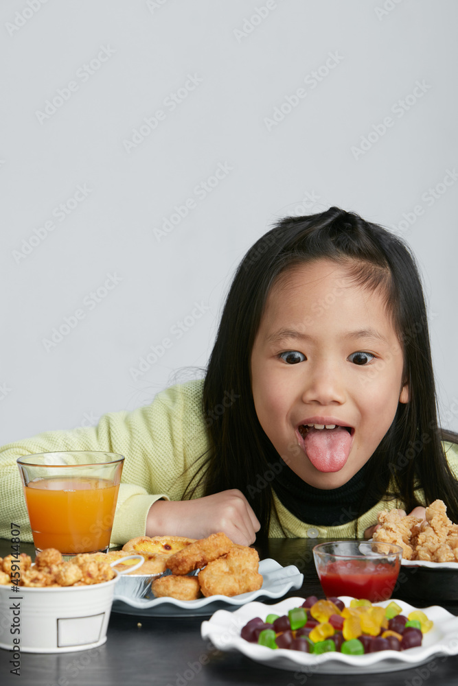 Asian little girl eating and playing indoors by herself Asian little girl eating and playing indoors by herself