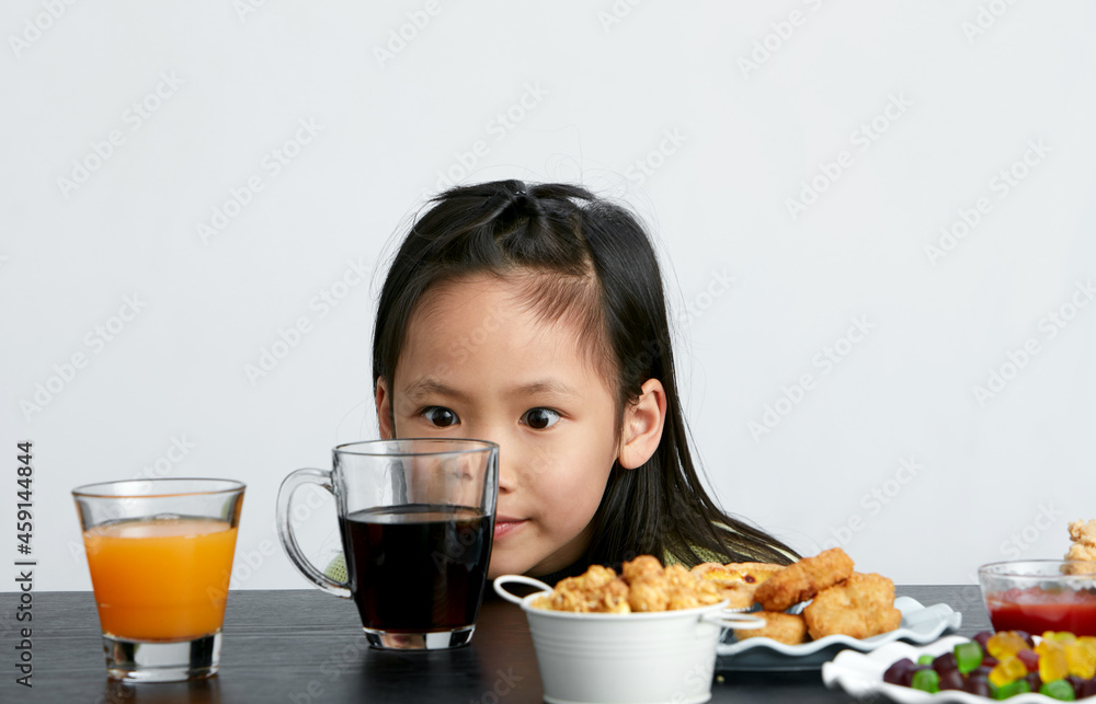 Asian little girl eating and playing indoors by herself Asian little girl eating and playing indoors by herself