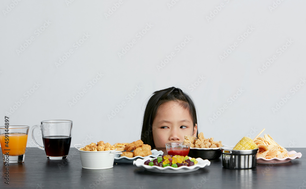 Asian little girl eating and playing indoors by herself Asian little girl eating and playing indoors by herself