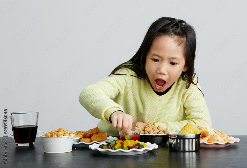 Asian little girl eating and playing indoors by herself Asian little girl eating and playing indoors by herself