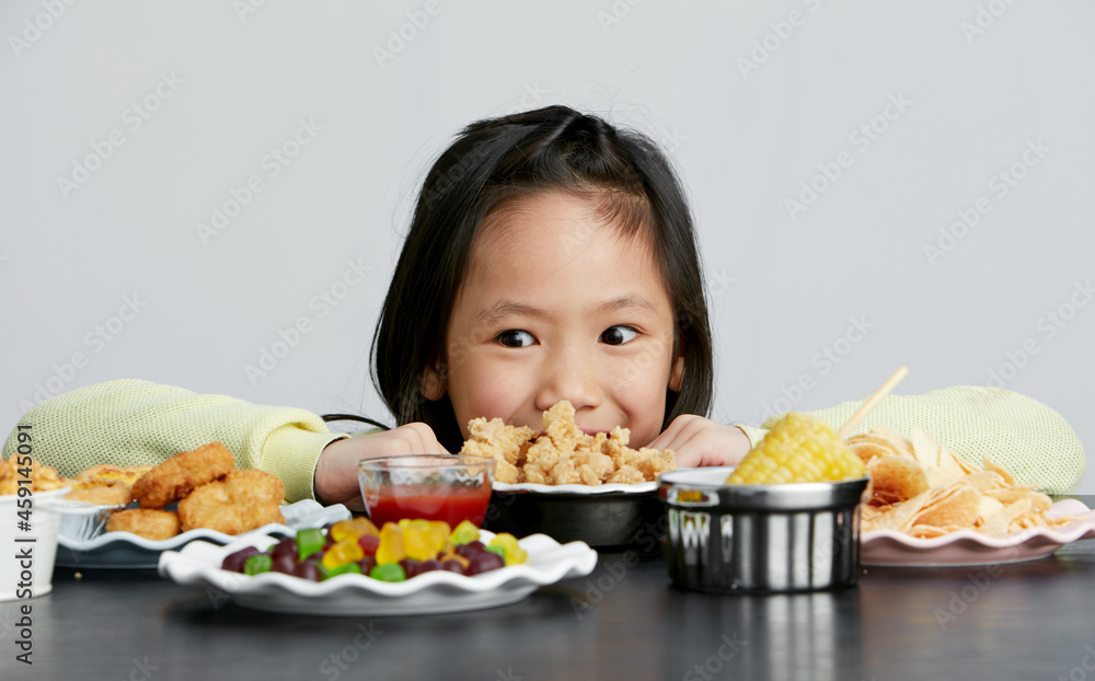 Asian little girl eating and playing indoors by herself Asian little girl eating and playing indoors by herself