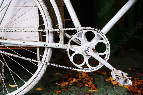 Fragment of a white bicycle in retro style. Painted frame and pedals for outdoor installation. Close-up photo