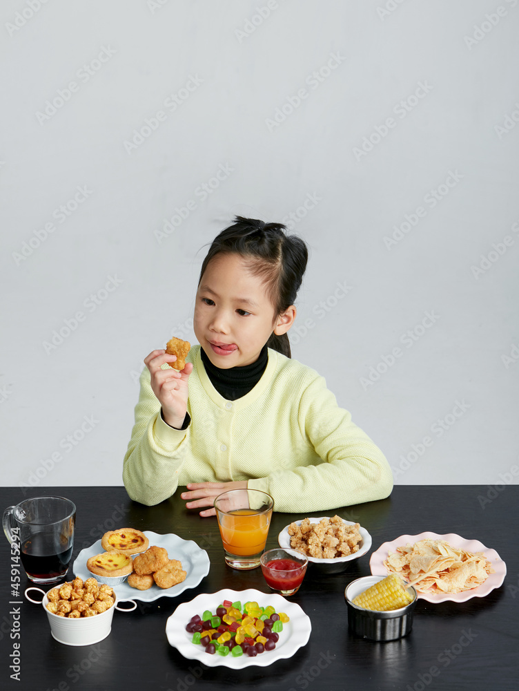 Asian little girl eating and playing indoors by herself Asian little girl eating and playing indoors by herself