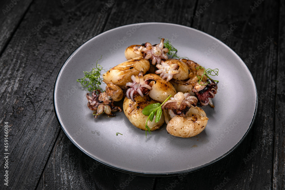 Seafood in a gray plate on a dark wooden table
Seafood in a gray plate on a dark wooden table