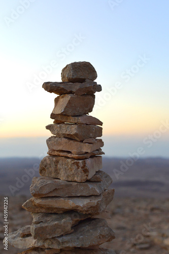 Cairn at sunrise  stones balances  pyramid of stones at sunset  concept of life balance  harmony and meditation. A pile of stones in desert mountains  crater Ramon  Israel. stack of rocks  stone tower