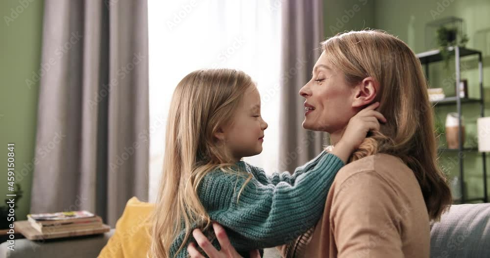 Side view of Caucasian young happy smiling mom and cute small daughter playing and having fun spending family time together in cozy home apartment. Mother and child. Positive emotions concept Close up Side view of Caucasian young happy smiling mom and cute small daughter playing and having fun spending family time together in cozy home apartment. Mother and child. Positive emotions concept Close up