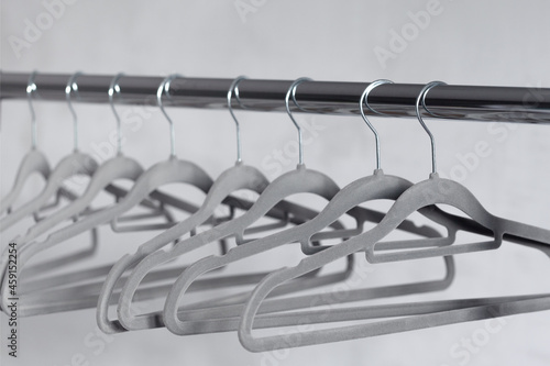 Modern grey empty hangers on neutral wall background photo