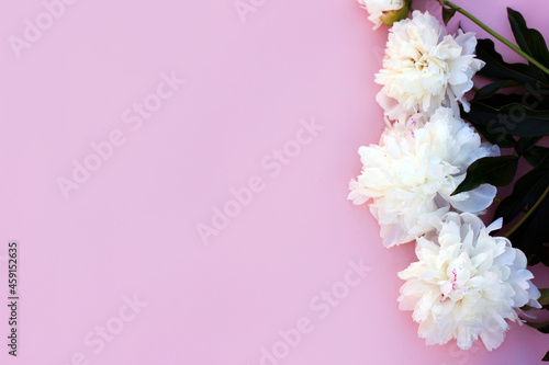 Mockup invitation, blank paper greeting card, pink table and peonies. Flower background. Flat lay, top view. © Elena