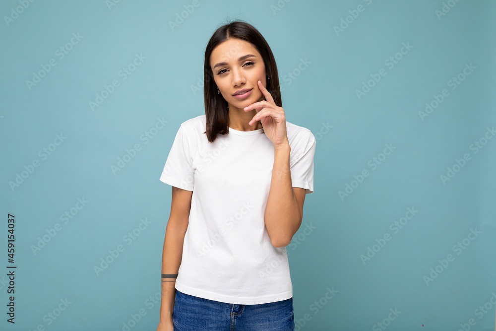 Attractive thoughtful dreaming thinking young brunette woman in casual white t-shirt for mockup isolated on blue background with free space Attractive thoughtful dreaming thinking young brunette woman in casual white t-shirt for mockup isolated on blue background with free space