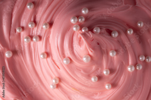 Pink icing frosting with small pearl sprinkles close up texture