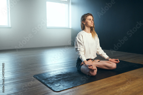 Young woman doing gyan mudra and pranayama. Yoga practice in the studio.