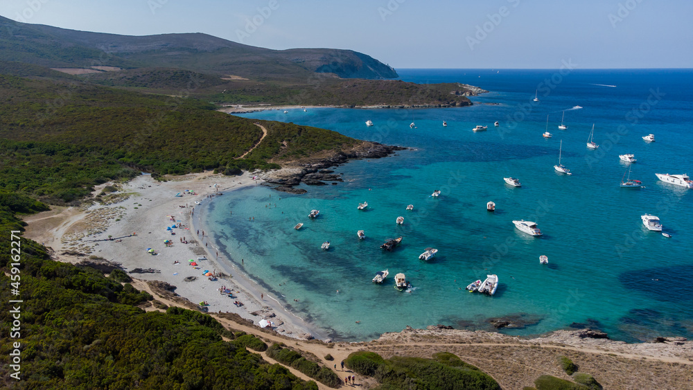 Aerial view of the Cala Genovese beach on the Cap Corse in Upper Corsica, France - Tourists enjoying the turquoise waters of the Mediterranean Sea in the wild scrub