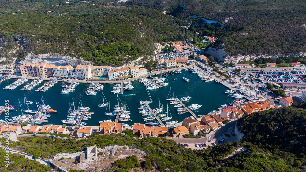 Aerial view of the marina of Bonifacio in the south of the island of Corsica in France - Old port tucked behind limestone cliffs in the Mediterranean Sea