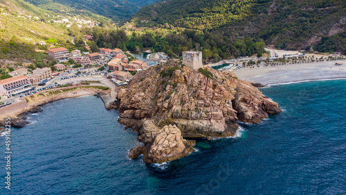 Aerial view of the ruins of the square Genoese tower of Porto at the end of the Gulf of Porto, Corsica, France - Remains of a medieval watchtower overlooking the Mediterranean Sea photo