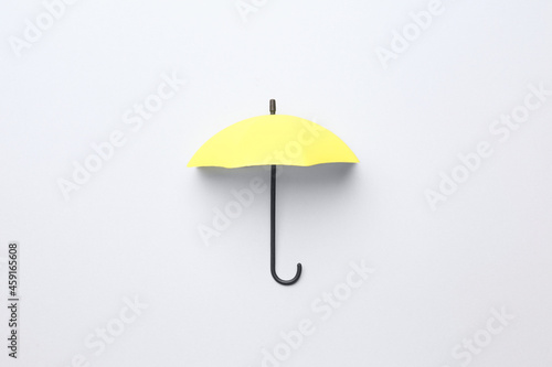 Yellow mini umbrella on white background, top view