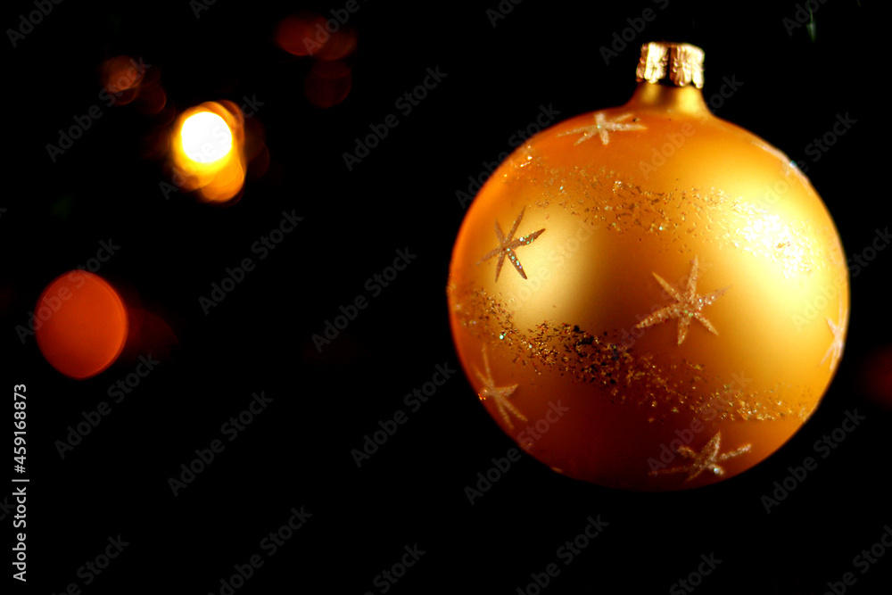 Gold colored Christmas ball with white snowflakes on dark blurred background - close up Gold colored Christmas ball with white snowflakes on dark blurred background - close up